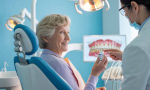 An elderly woman with a dentist discussing how medications affect oral health